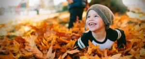 kid playing in leaves