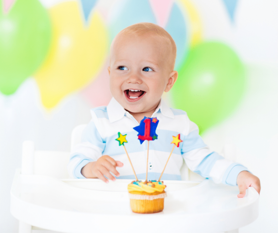 little boy blowing out candle for first birthday